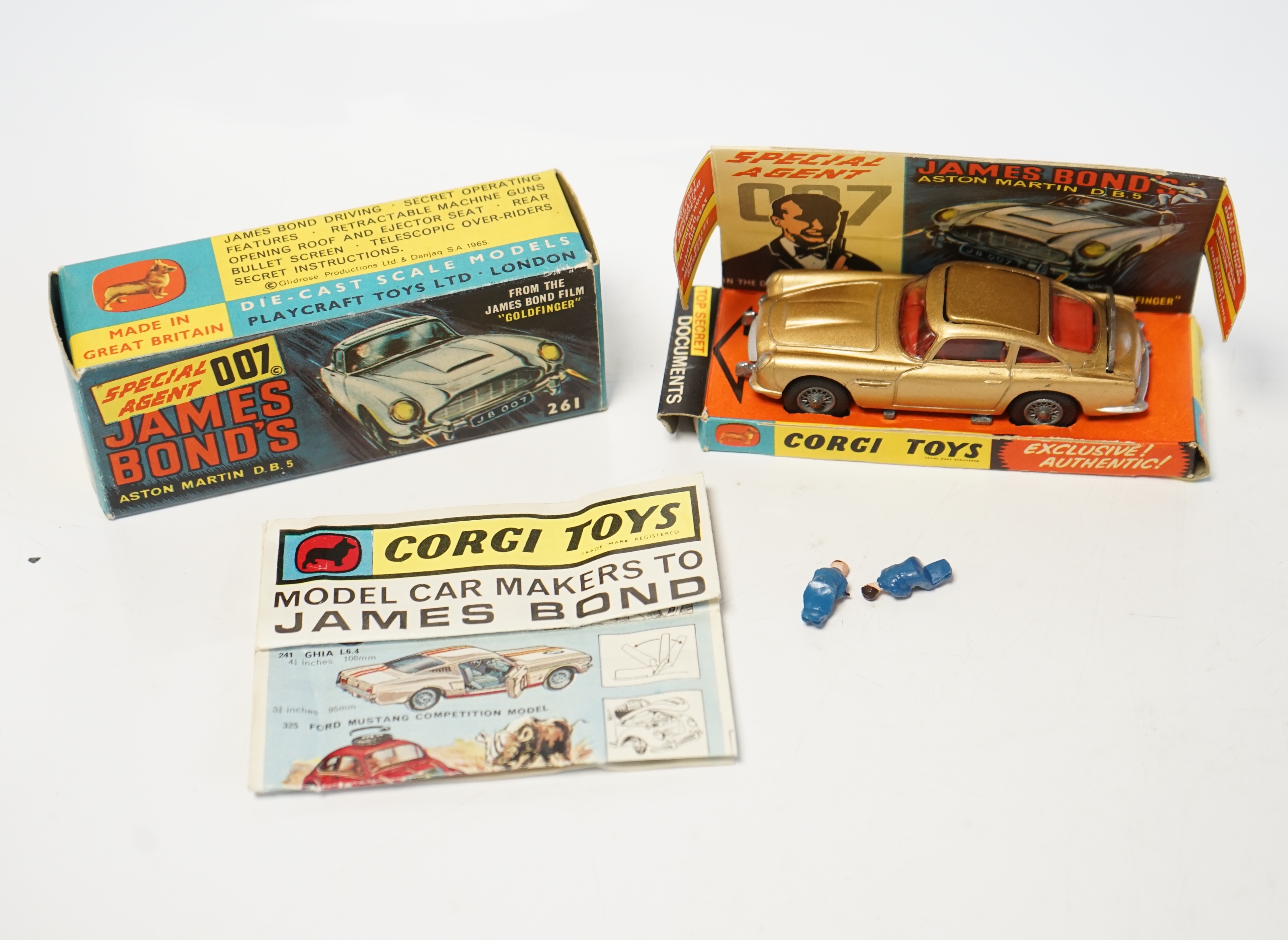 A boxed Corgi Toys James Bond 007 Aston Martin (261), a first issue example in gold finish, boxed with inner display stand, envelope for secret instructions, top-secret leaflet, sheet of two unused lapel stickers, and th